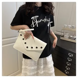 Detail of white leather envelope clutch with metal grommets and detachable wrist strap
