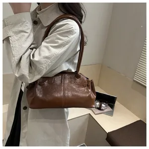 Minimalist brown leather shoulder bag shown on shoulder for professional daily commute