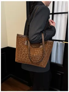 Détail d'un sac cabas à imprimé léopard avec anses brunes et lettrage doré NEW YORK
