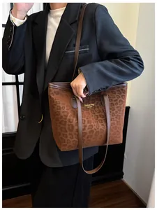 Détail du cabas léopard avec lettrage doré et poignée en cuir marron élégant