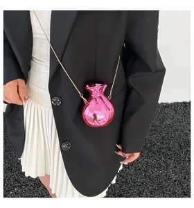 Dettaglio mini borsa a tracolla rosa acceso con finitura metallica lucida e catena oro