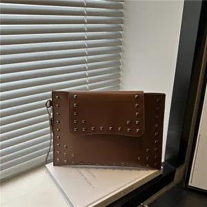 Elegant brown leather envelope clutch with silver square studs and wristlet strap