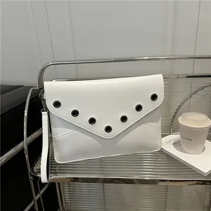 Minimalist white envelope clutch bag with black metal eyelets and detachable wrist strap