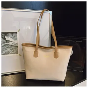 Détail d'un sac cabas crème chic avec bordure kaki et lettrage doré New York