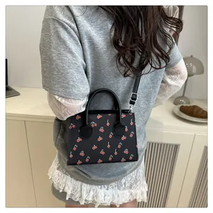 Chique zwarte tas met kersenprint gestyled met casual outfit in een gezellige kamer
