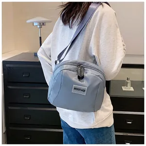 Close-up of gray blue waterproof nylon bag featuring adjustable strap and brand patch