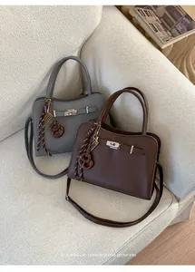 Detail of gray and brown荔枝纹 grain leather handbags with silver hardware and tassel