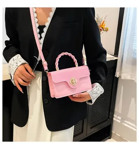 Détail du sac bandoulière rose avec boucle fleur dorée et poignée en spirale