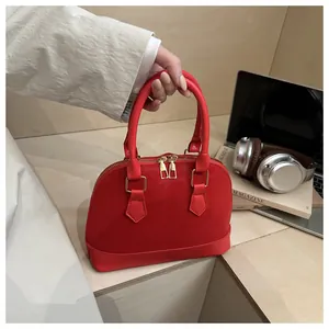 Macro shot of red leather shell bag details with golden zippers and sturdy top handles