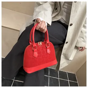 Detail of red shell handbag featuring subtle leopard print and gold hardware accents