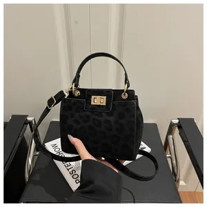 Détail du sac à main noir mat imprimé léopard avec fermoir doré et poignée élégante