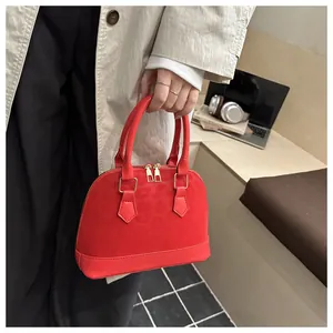 Close-up of red shell bag with leopard texture and elegant gold zipper details