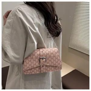 Detailansicht der rosa Umhängetasche mit M-Muster und Silberkette getragen am Model