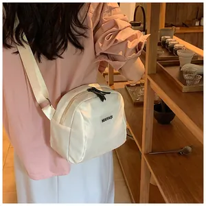 Detail of a creamy white PU leather makeup bag featuring a black NUOYAQI brand label