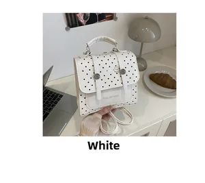 Detailed view of the polka dot backpack featuring decorative straps and a cute cartoon print