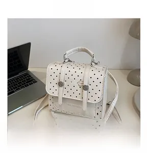 Close-up of retro polka dot bag with silver buckles and a hamburger graphic