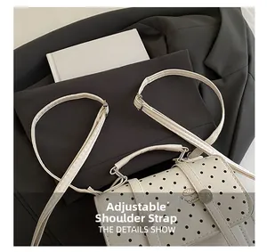 Detail view of the adjustable shoulder strap on a white polka dot patterned backpack