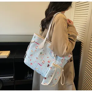 Detail der hellblau karierten Stepptasche mit Bärenstickerei und kleiner Münztasche