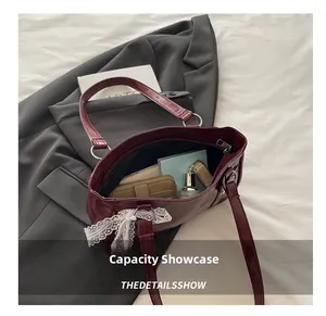 Interior view showing capacity of burgundy faux leather handbag with lace bow detail