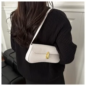 Close-up of white crocodile pattern shoulder bag with a gold metal oval lock detail