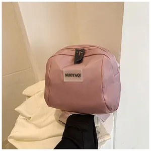 Detailed view of pink nylon cosmetic bag with durable metal zippers and top handle