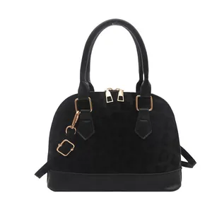 Minimalist black leopard print shell bag with golden hardware and crossbody strap