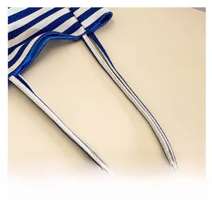 Close-up of blue and white striped canvas tote bag showing handle attachment and lining