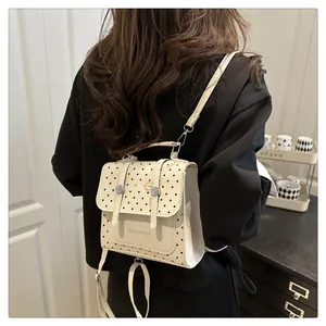 Polka dot small backpack worn by model showing back view and adjustable straps
