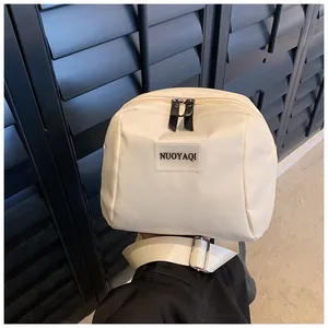 Detail of cream PU leather makeup bag showing top dual zippers and adjustable wide strap