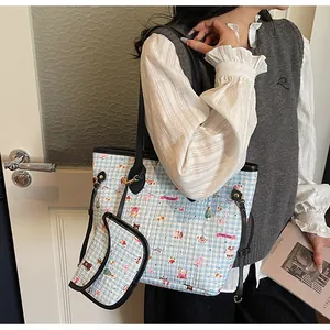 Detail der blauen gesteppten Bärtasche mit schwarzen Ledergriffen und kleiner Tasche