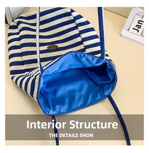 Detail view of the spacious blue fabric interior and striped canvas tote bag structure