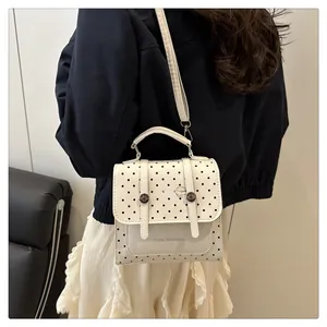 Polka dot backpack with top handle and adjustable strap shown on model outdoors