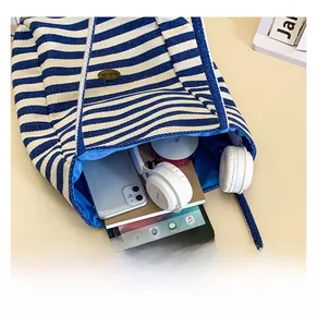 Interior view showing large capacity for tablet, headphones and books in striped tote bag
