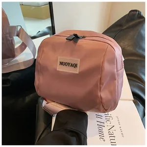 Macro view of mauve nylon makeup pouch with zip closure and fabric strap detail