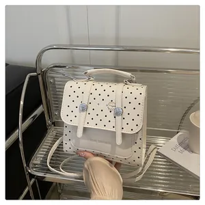 Detailed view of white polka dot bag with Tidal Dryness text and adjustable strap