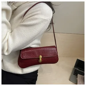 Burgundy faux crocodile leather underarm bag featuring a vintage gold clasp on a model