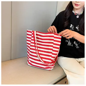 Detail of red and white striped canvas tote bag showing the texture and handle