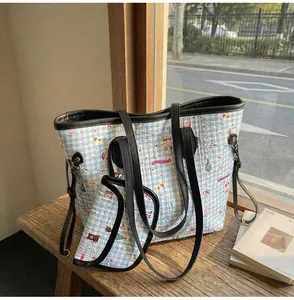 Detailansicht der gesteppten Karo-Tasche mit Bärenmuster und kleinem passenden Etui