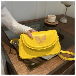 Vue détaillée du sac à main jaune avec broderie papillon rose et crochets dorés
