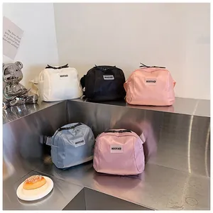 Compact nylon crossbody belt bags in five colors displayed on a modern metal pedestal