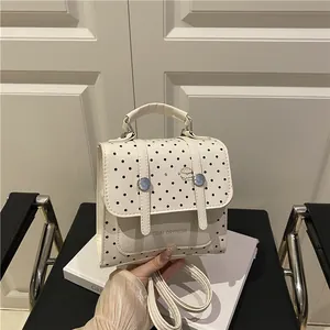 Retro cream backpack with black polka dots, burger brooch and metal buckle detail