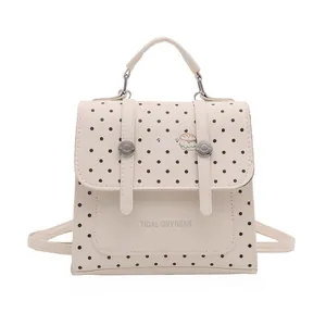 Chic cream mini backpack with black polka dots and decorative metal buckles for women
