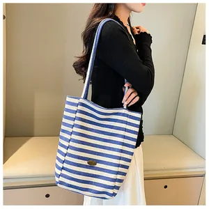 Detail view of large canvas tote bag featuring classic blue and white vertical stripes