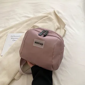 Pink nylon crossbody bag with dual zippers and adjustable strap for women travel use