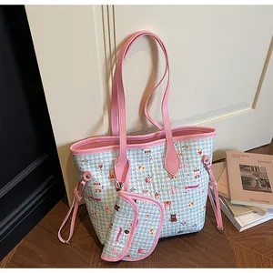 Detailansicht einer gesteppten blauen Tragetasche mit rosa Trägern und kleiner Zusatztasche