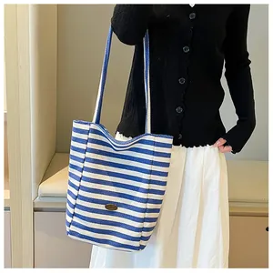 Detail of blue and white striped canvas tote bag with handmade oval logo patch