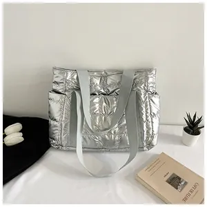 Détail du grand sac cabas argenté matelassé avec texture métal et poches latérales