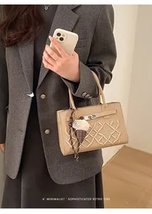 Macro detail of beige crossbody bag with woven embroidery and ice cream charm