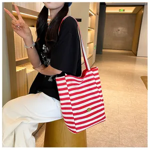 Detail of red and white striped canvas tote bag showing the textured material and logo