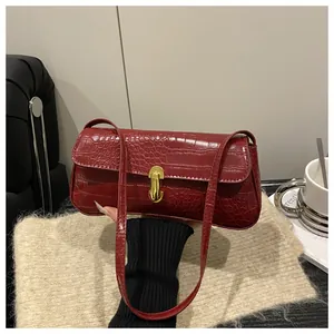 Close-up of a burgundy crocodile pattern shoulder bag with a gold metal lock decoration
